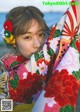 A young girl in a colorful kimono on the beach.